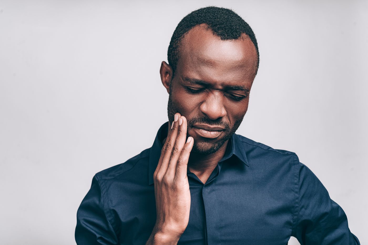 Man touching jaw with hand showing discomfort