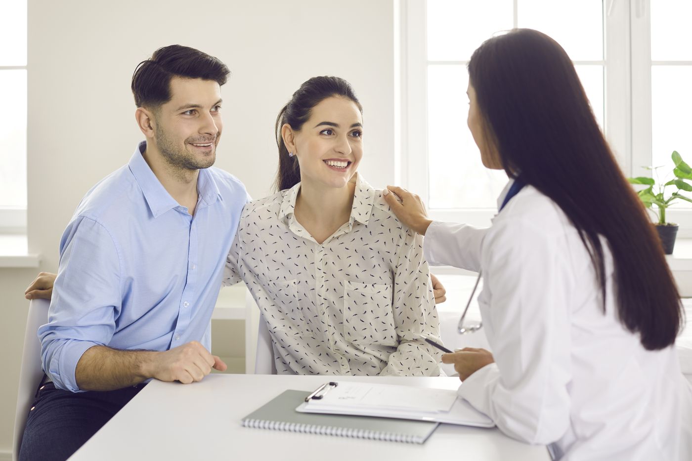 Dental professional consulting with a couple in an office setting