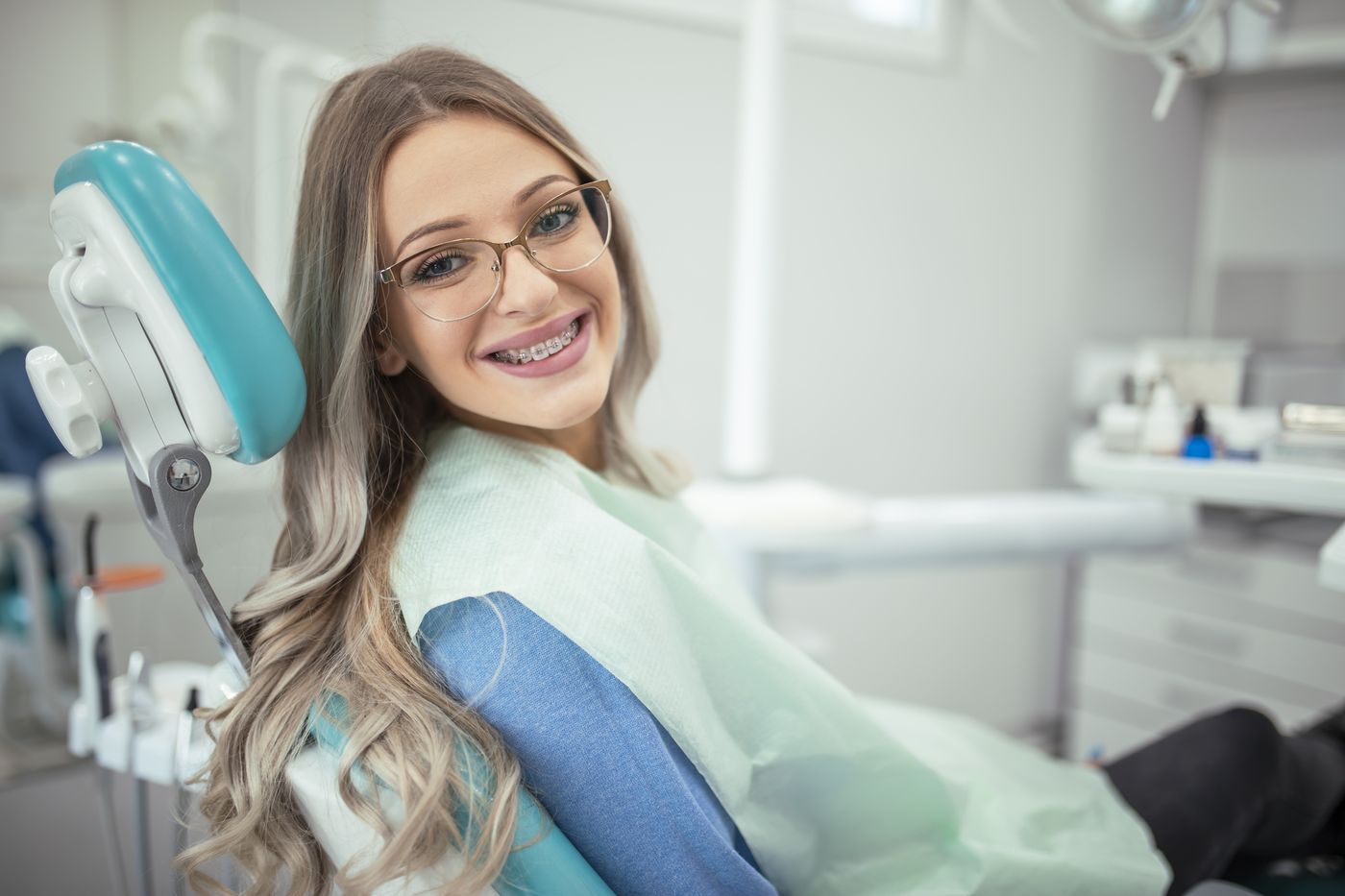 Smiling woman with braces in dental chair
